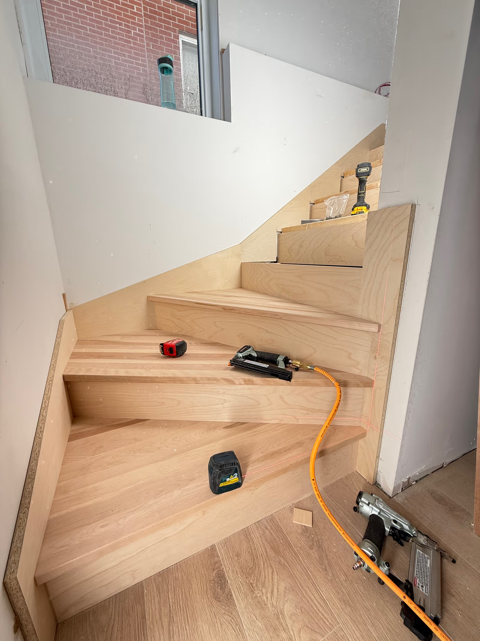 Escalier en bois franc en cours d’installation avec marches sur mesure et finition intérieure moderne