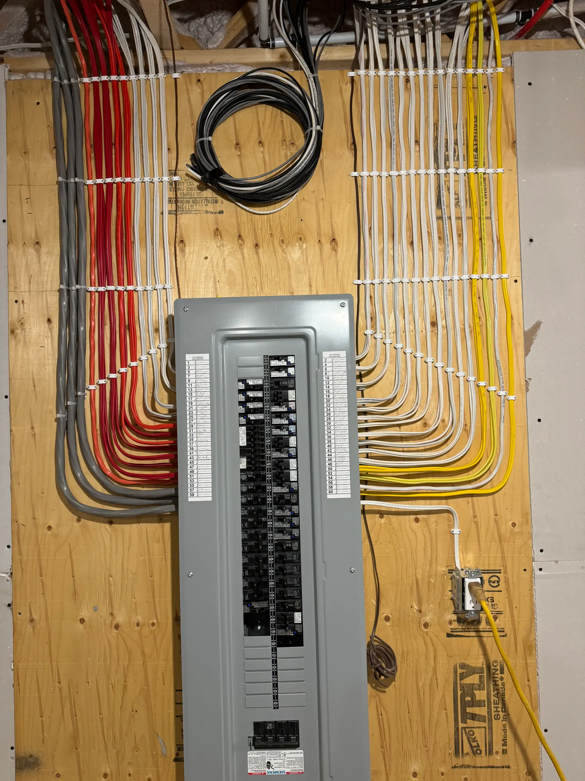 Panneau électrique résidentiel avec câblage structuré et organisé sur mur en bois