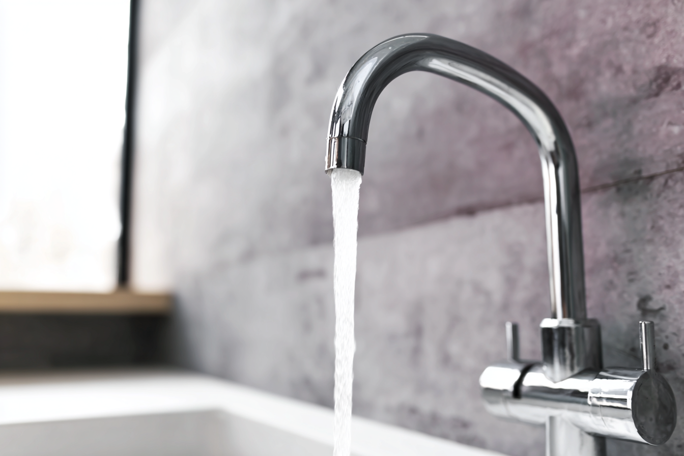 Robinet chromé moderne avec jet d'eau courante dans une cuisine ou salle de bain au design contemporain