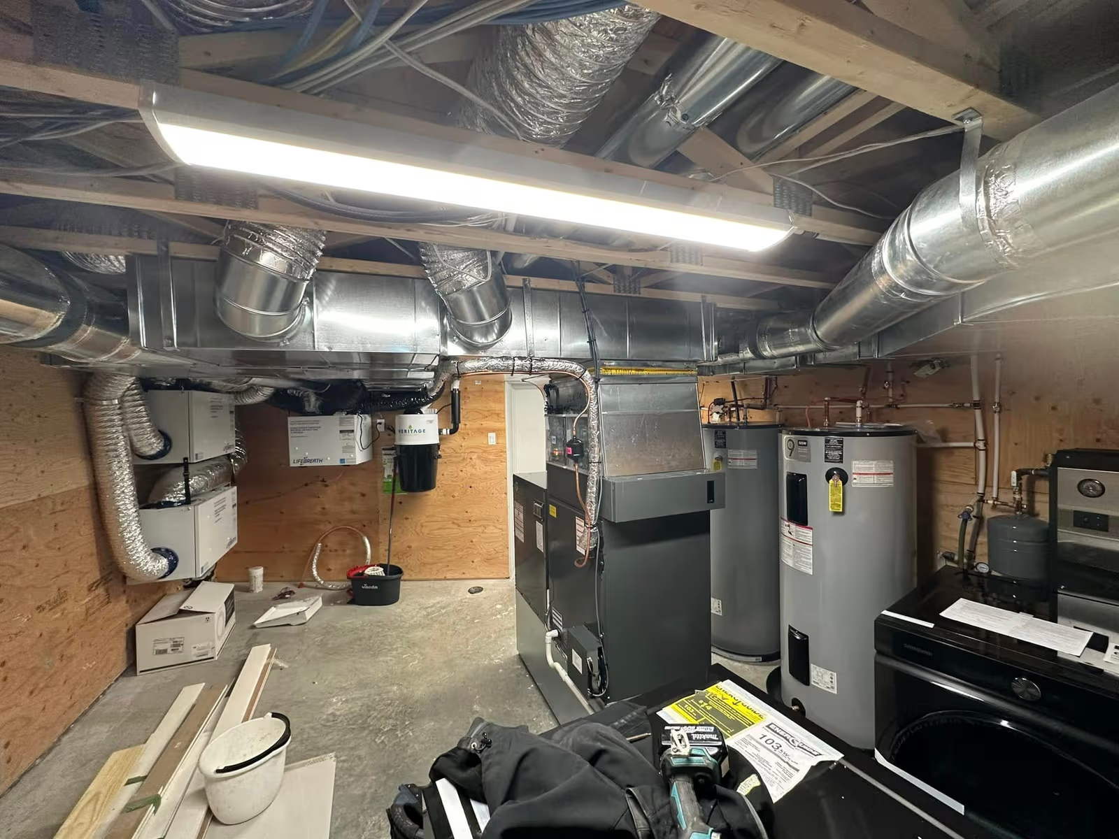 Basement mechanical room with furnace, water heater, ventilation ducts and residential heating equipment