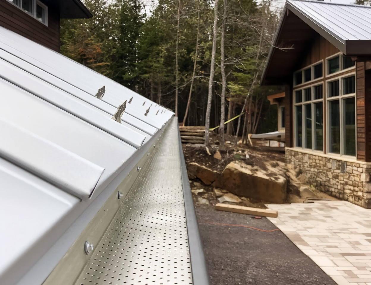 Metal roof with perforated gutter guard installed to prevent debris buildup.