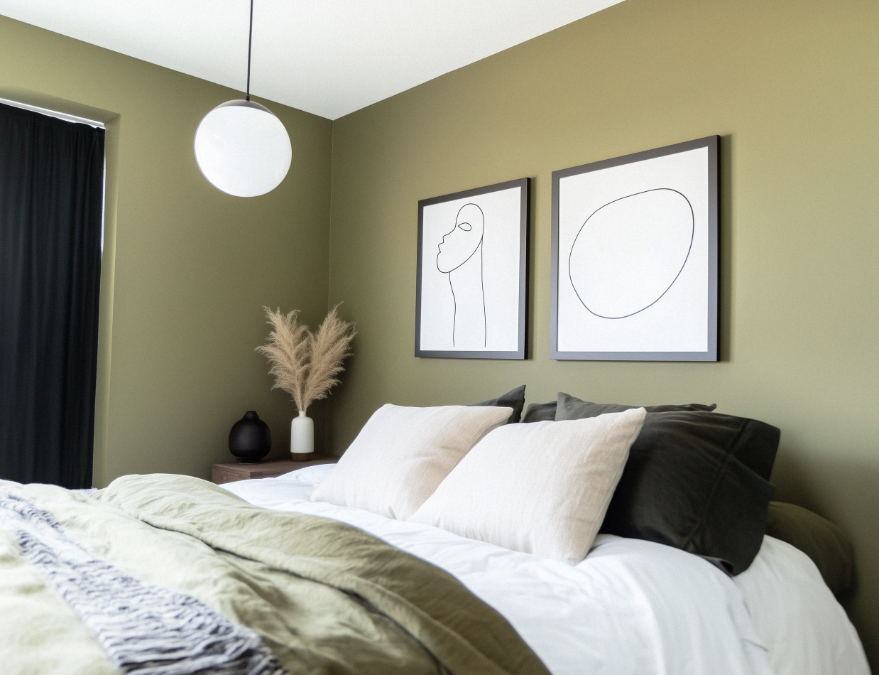 Modern room with olive green walls, white bed, decorative cushions and minimalist frames