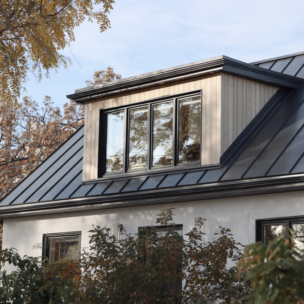 Modern metal roof with light wood dormer and large windows on contemporary home