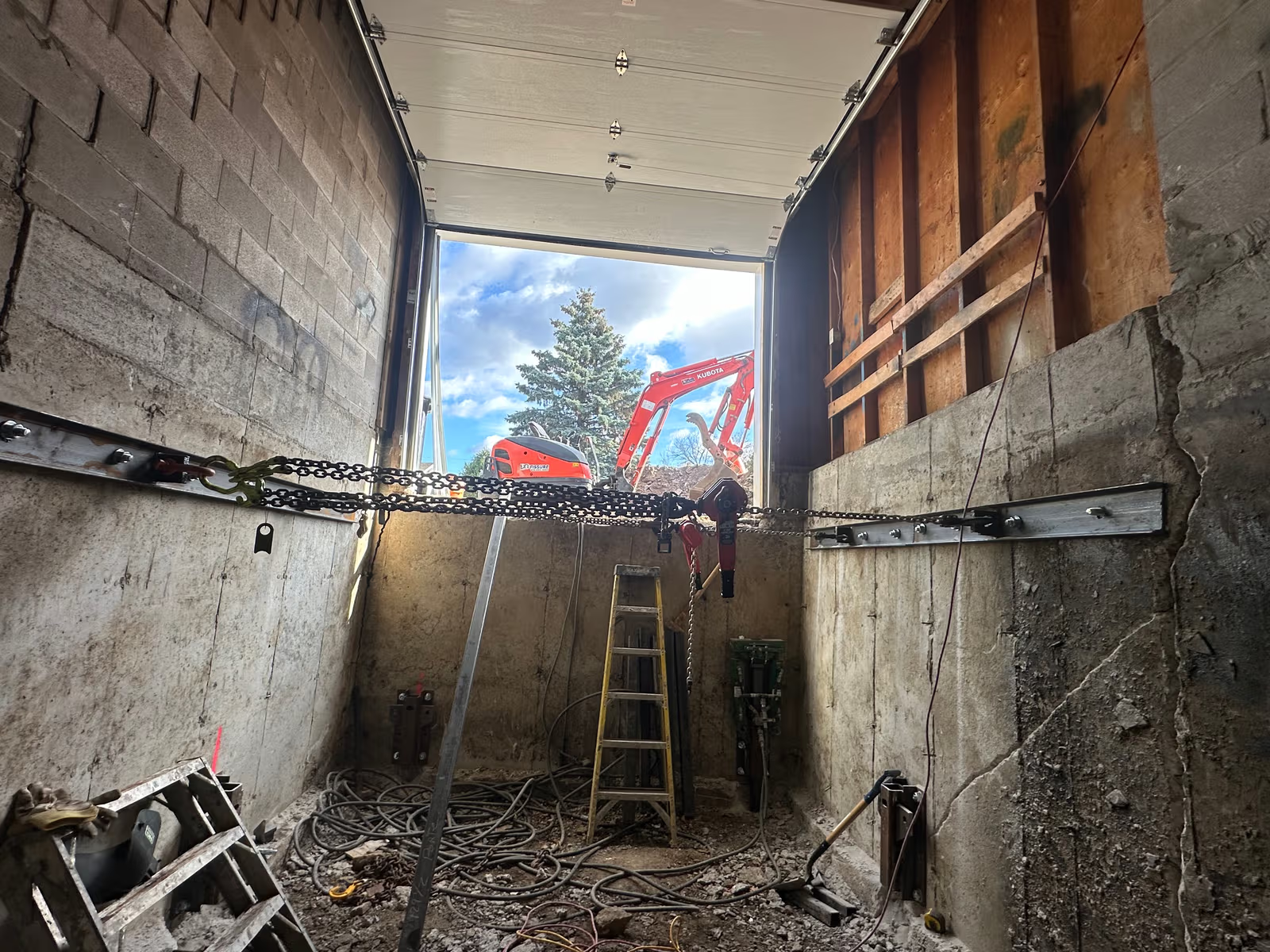 Underpinning work with garage excavation to stabilize the foundation and lower the basement floor level