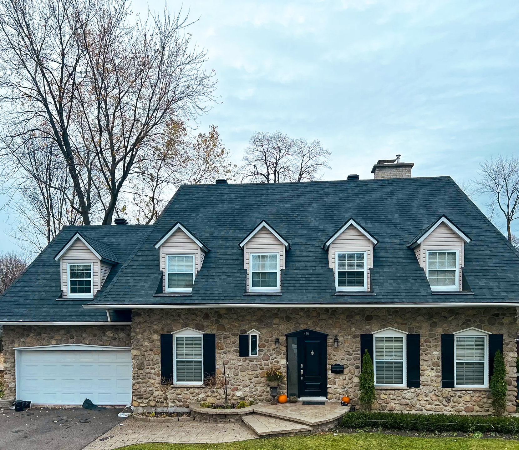 Maison en pierre avec toiture à lucarnes et garage double intégré