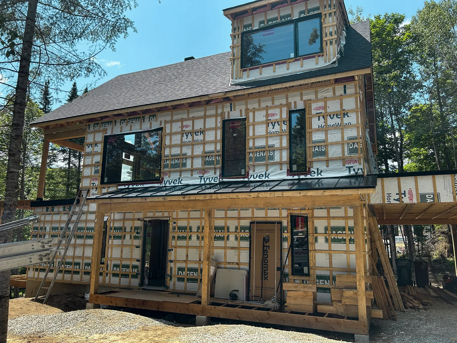 House under construction with wooden frame, insulation and weather shields installed on the facade