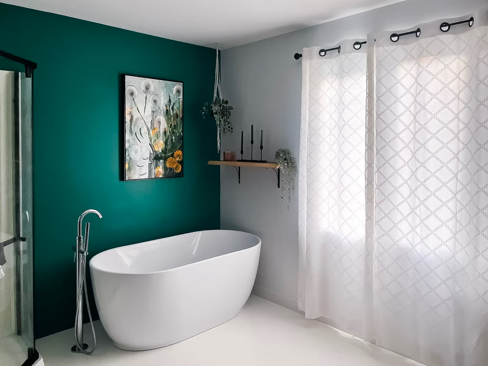 Salle de bain moderne avec baignoire autoportante, mur vert accent, robinetterie chrome et rideaux blancs.