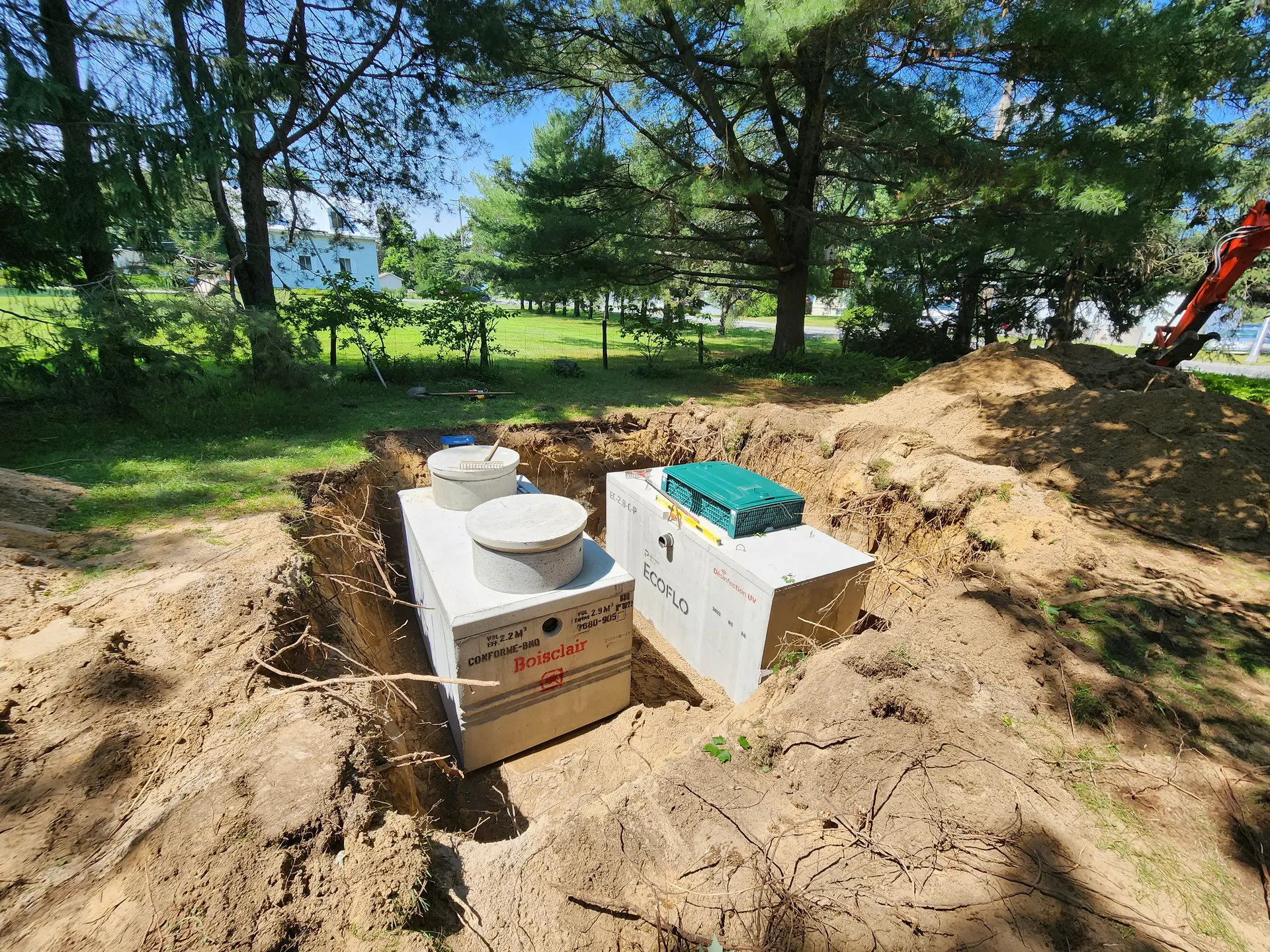 Installation d'une fosse septique Ecoflo avec système de traitement des eaux usées dans un projet résidentiel.
