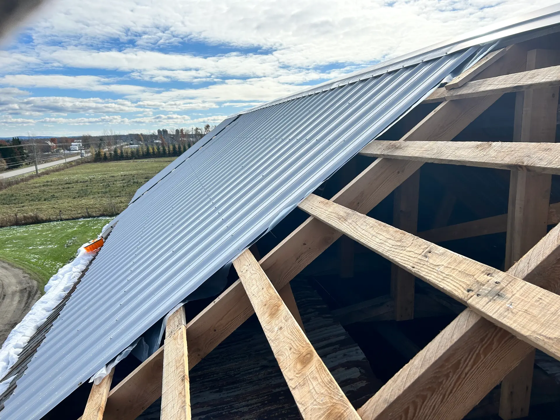 Metal roof installation on a wooden framework.