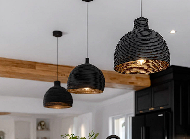 Suspensions noires modernes installées électriquement au plafond d’une cuisine contemporaine avec poutres en bois