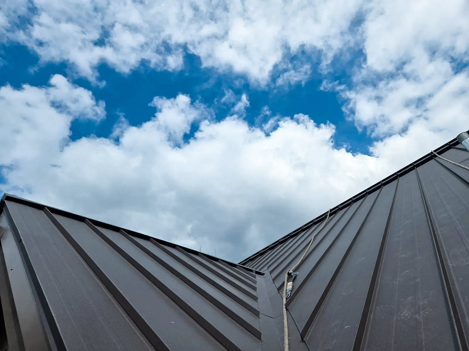 New metal sheet roof with blue sky and clouds in the background