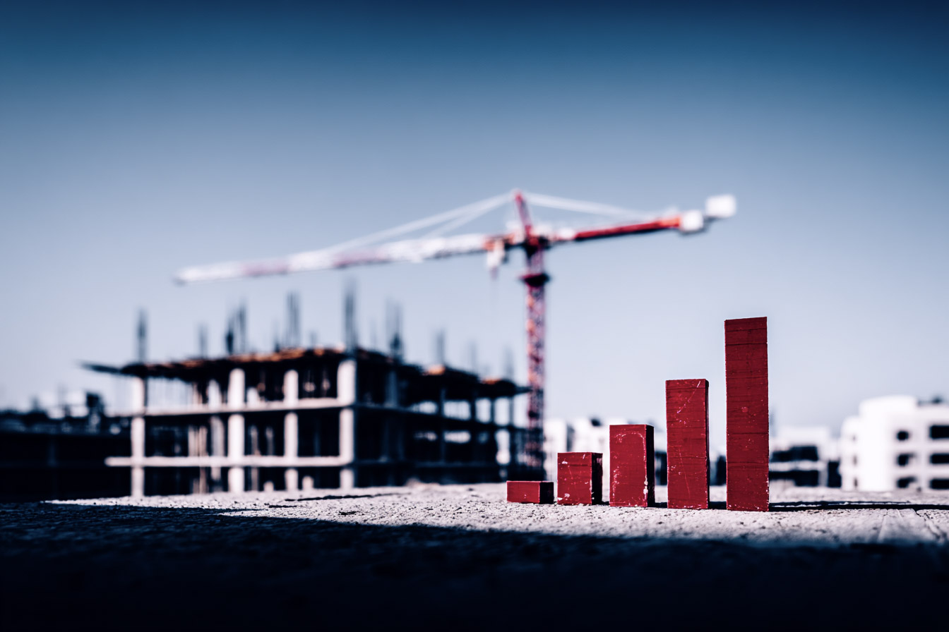 Growth chart made of red blocks in the foreground of a construction site with crane and building under construction in the background.