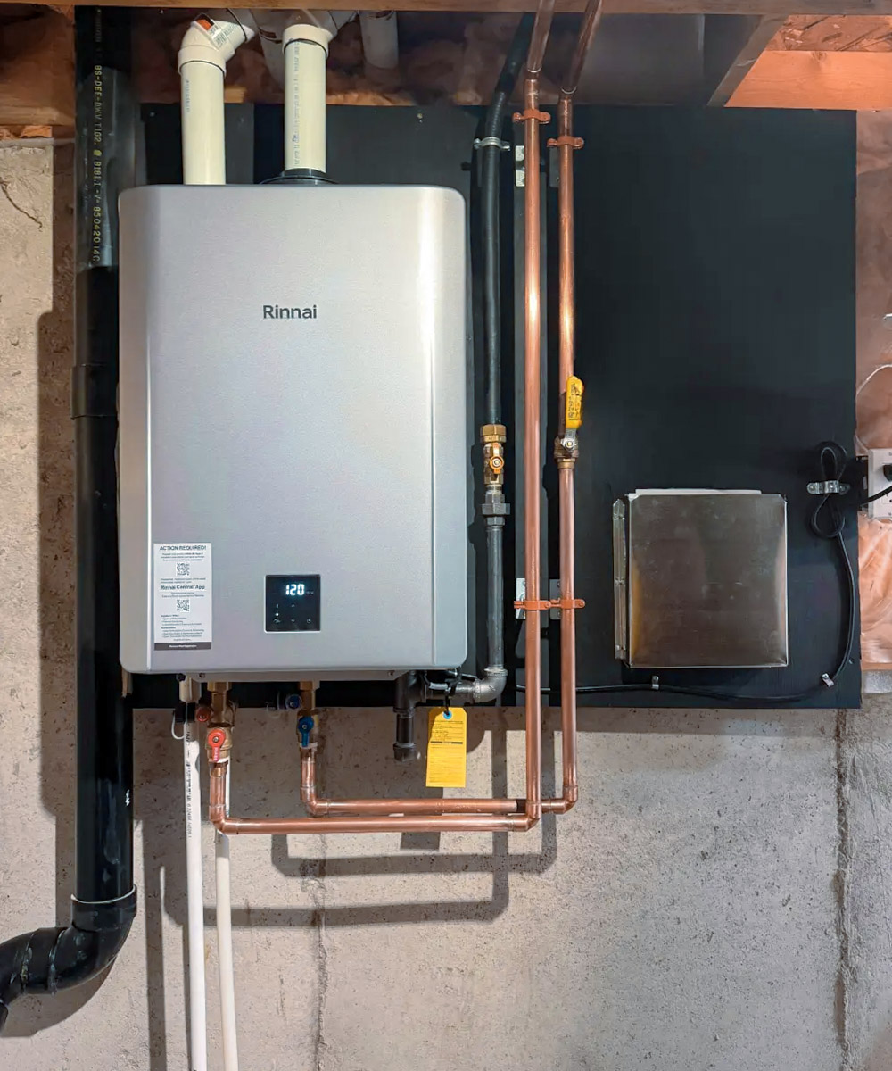 Rinnai wall-mounted tankless water heater with copper piping and venting system installed in a basement