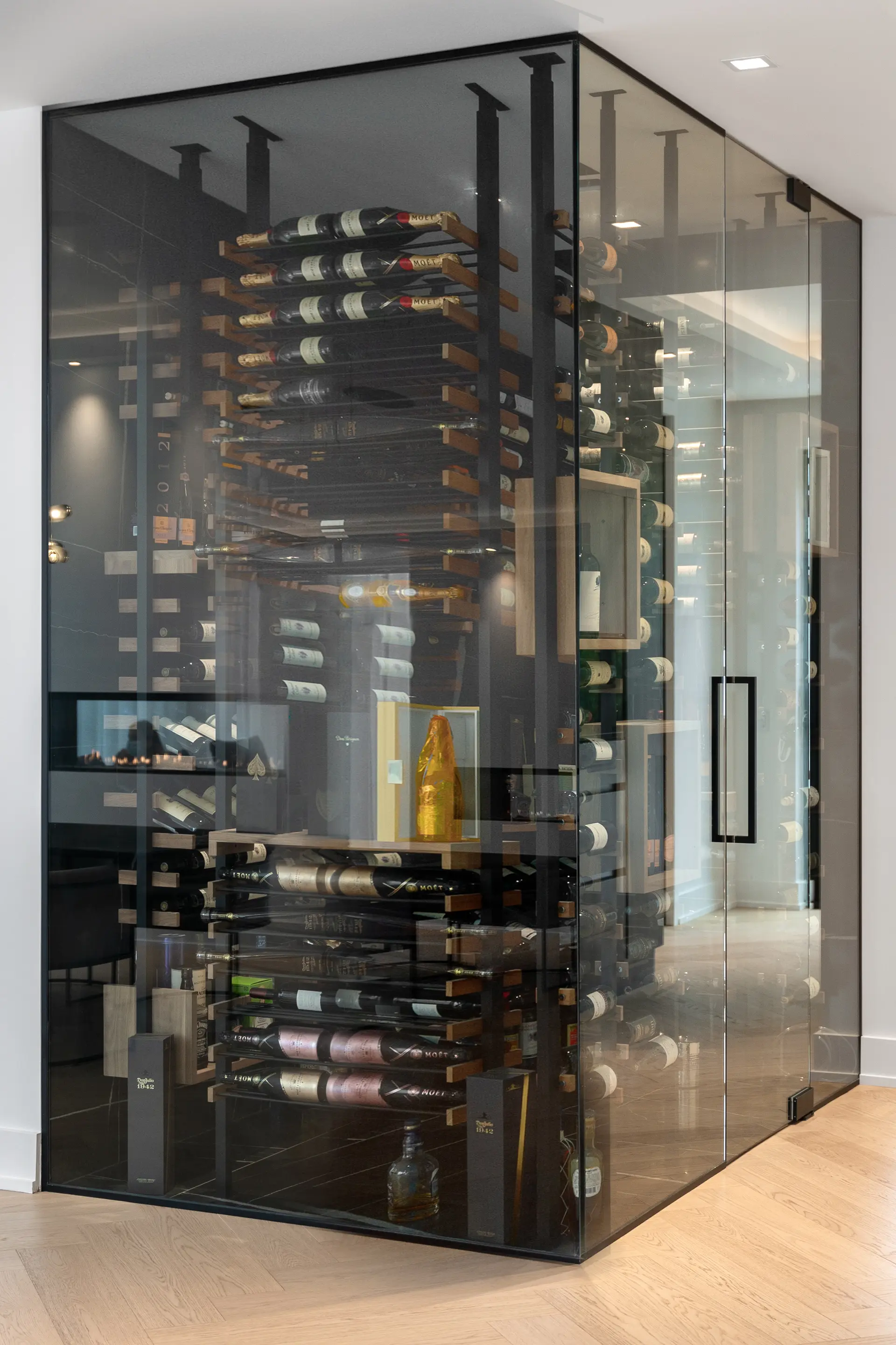 Custom glass wine cellar with metal racks, vertical bottle storage and premium contemporary design