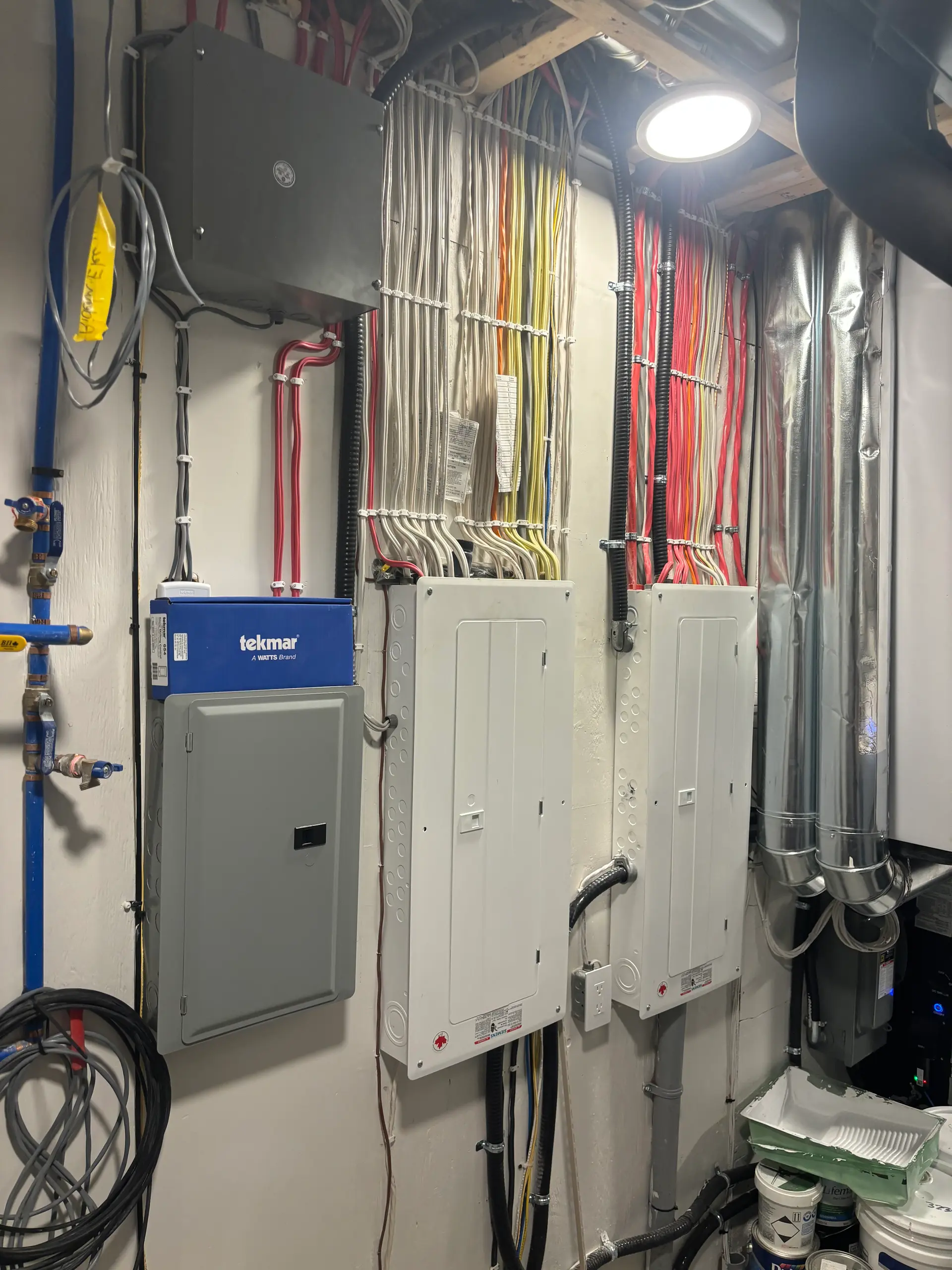 Panneaux électriques résidentiels avec câblage structuré multicolore installés dans une salle technique