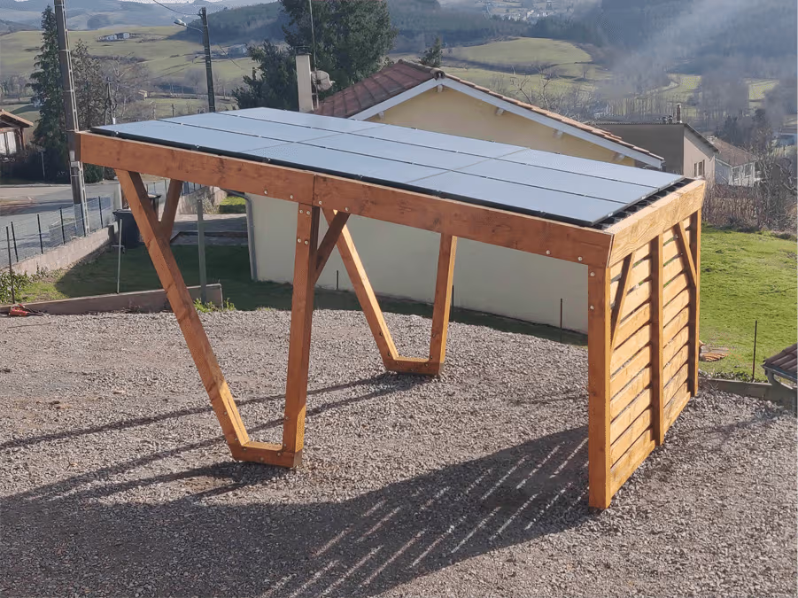 Wood solar carport with photovoltaic roof panels and outdoor structure on gravel ground