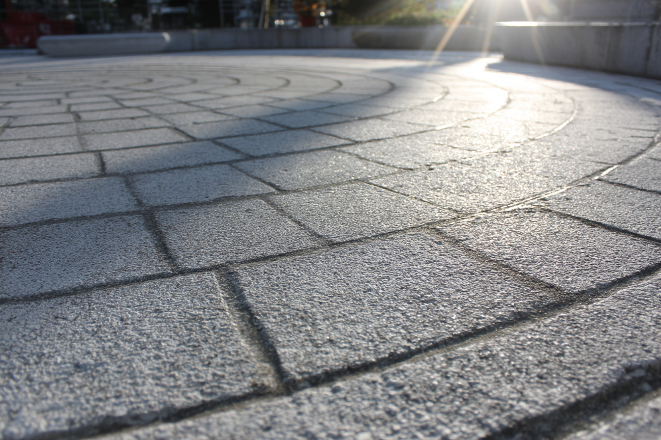 Surface en béton estampé gris clair avec motif en arc de cercle, finition lisse et scellée pour une entrée extérieure élégante