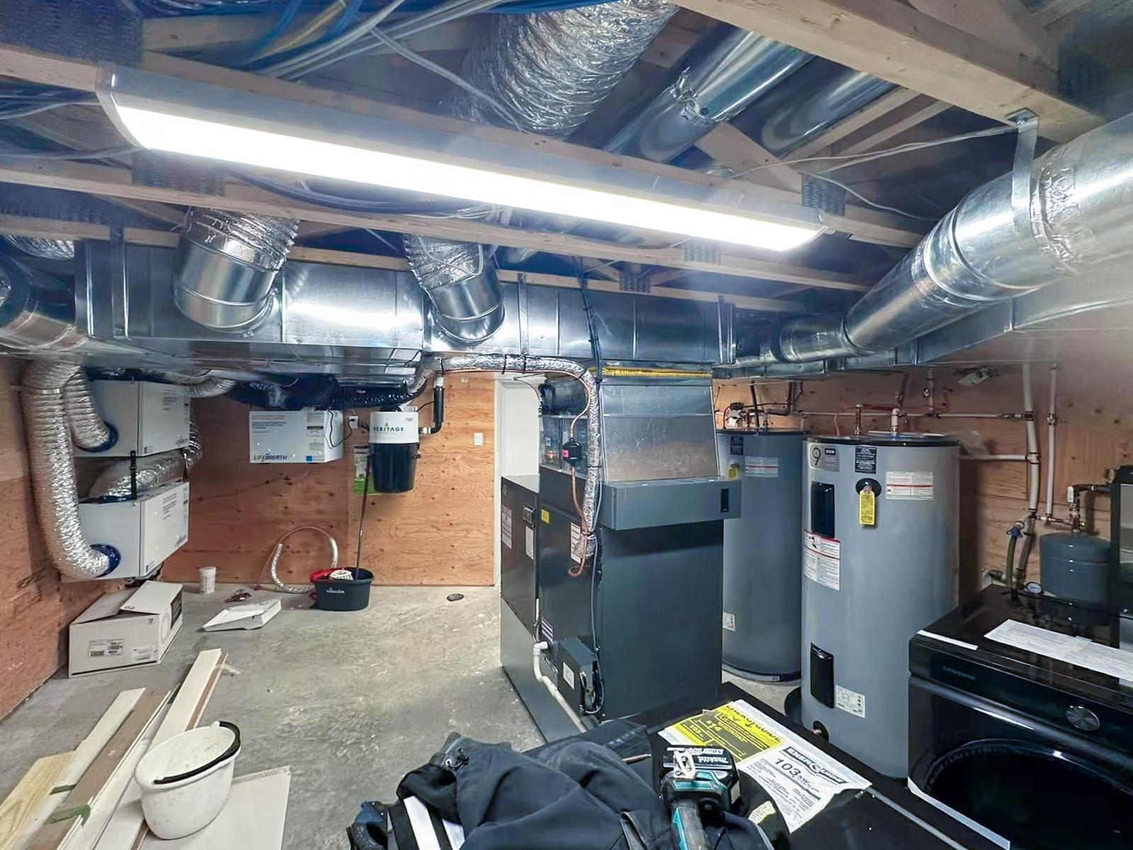 Basement mechanical room with furnace, water heater, ventilation ducts and residential heating equipment