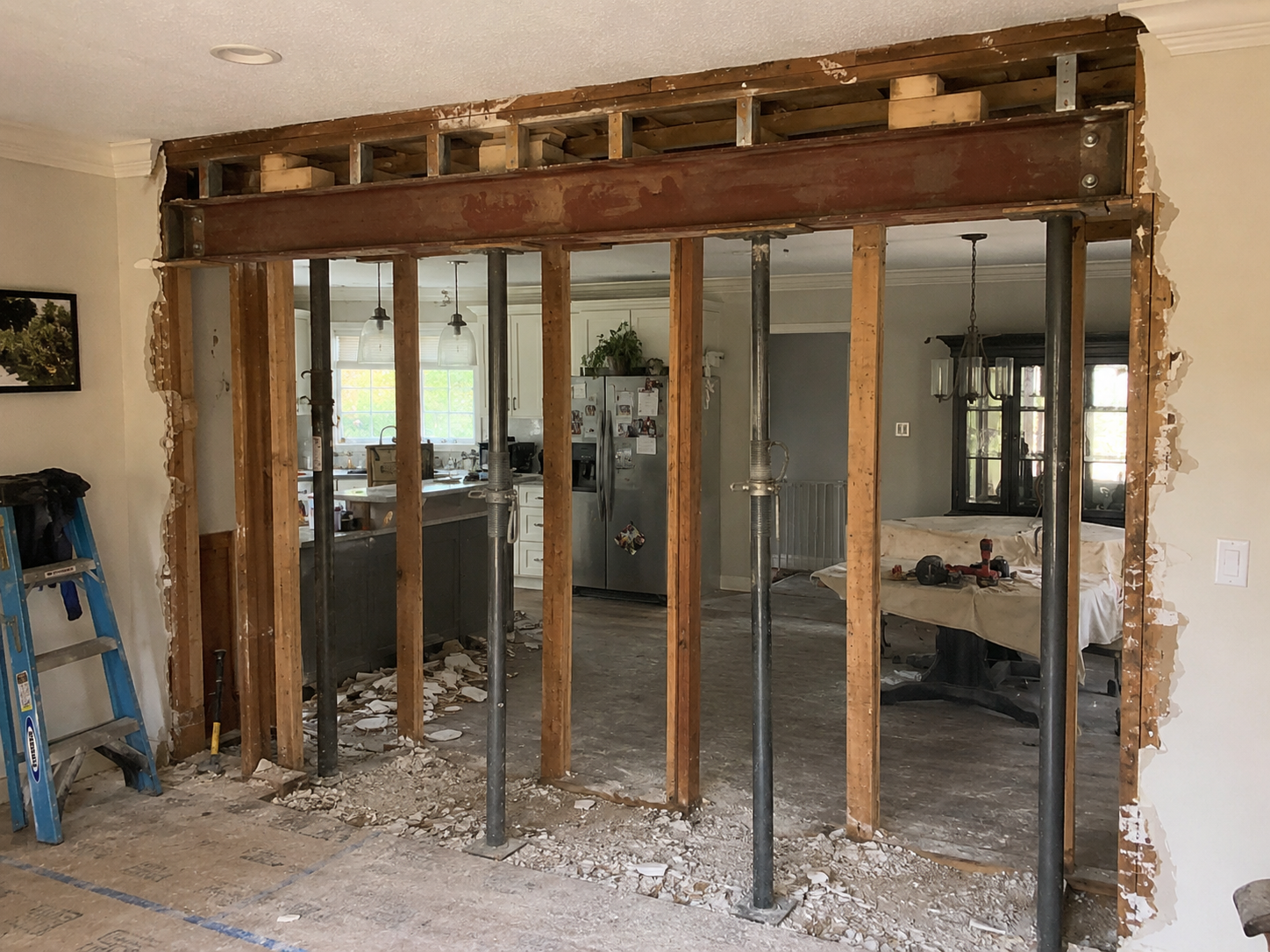 Load-bearing wall opening with steel beam, wood studs and temporary supports in a home renovation