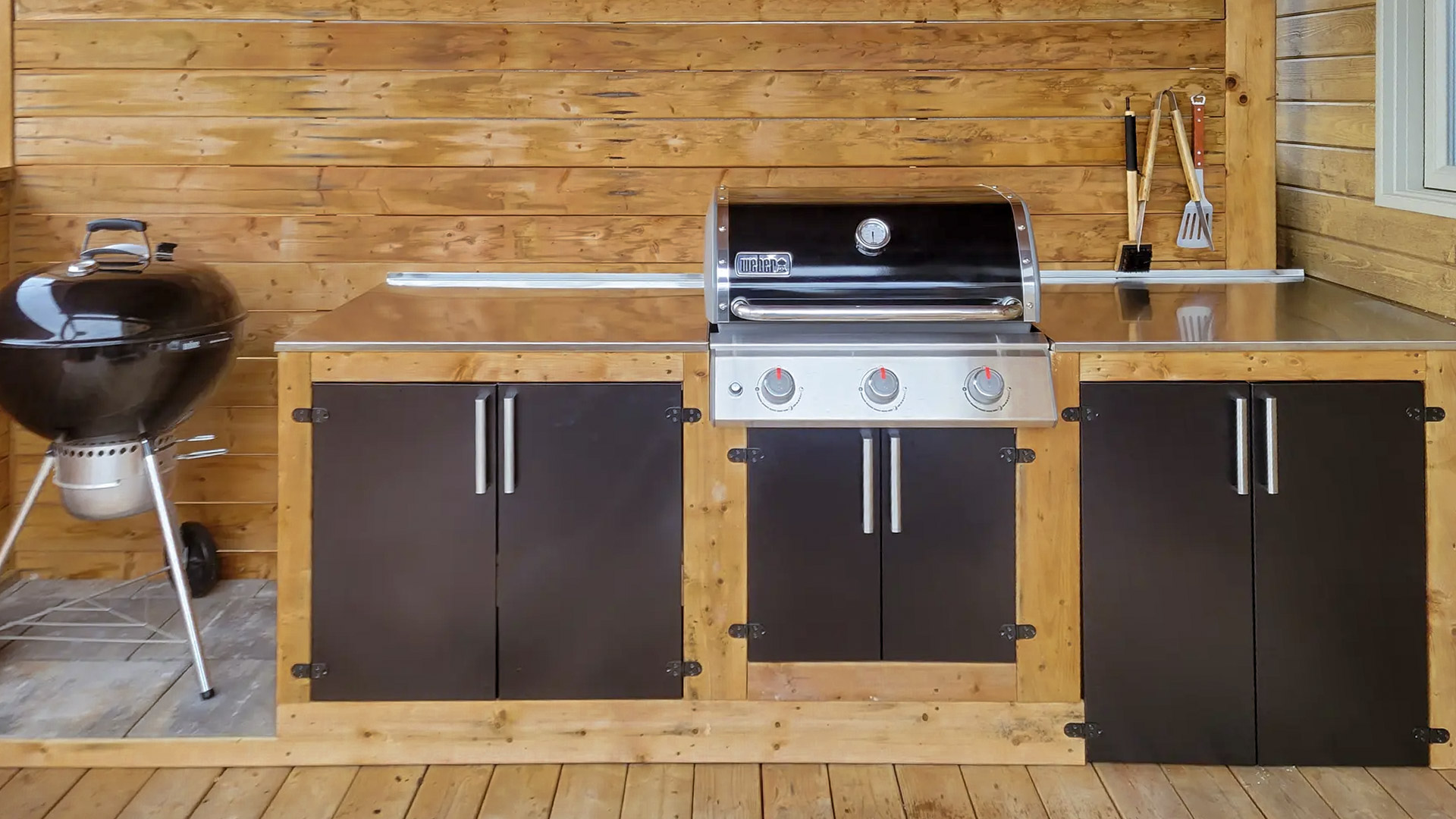 Wooden outdoor kitchen with built-in barbecue and stainless steel worktop