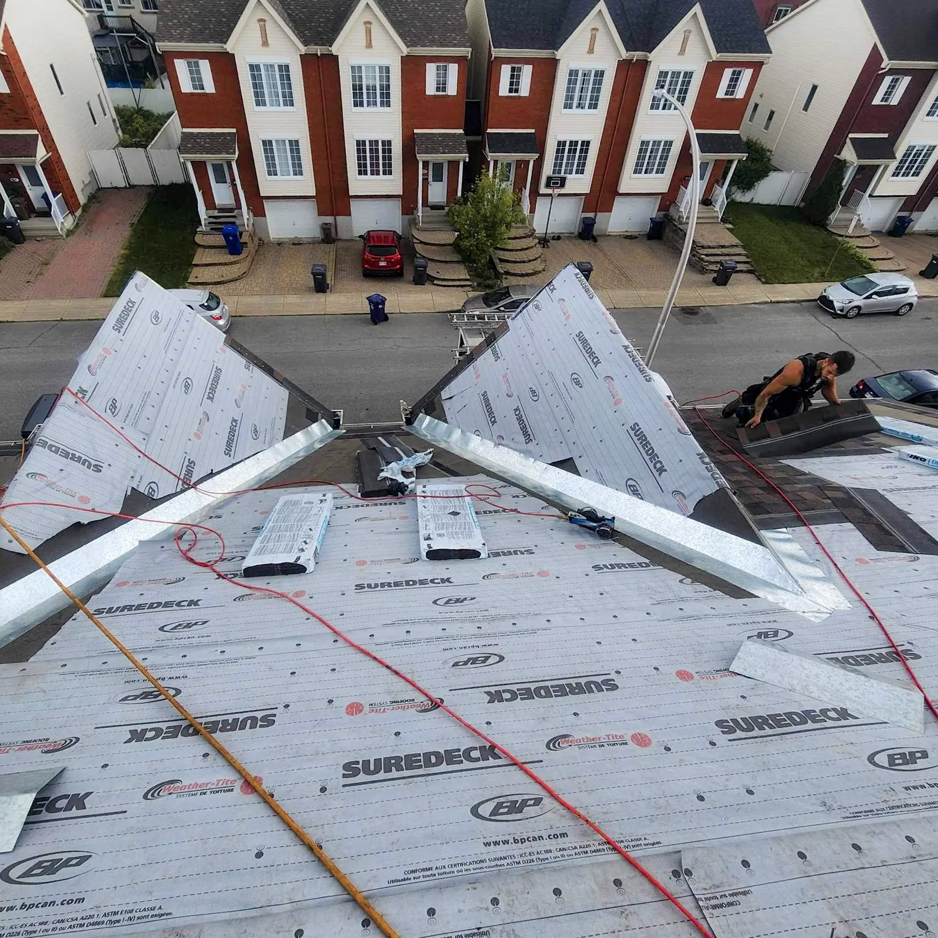 Travaux de réfection de toiture avec sous-couche imperméable installée sur un toit résidentiel en pente