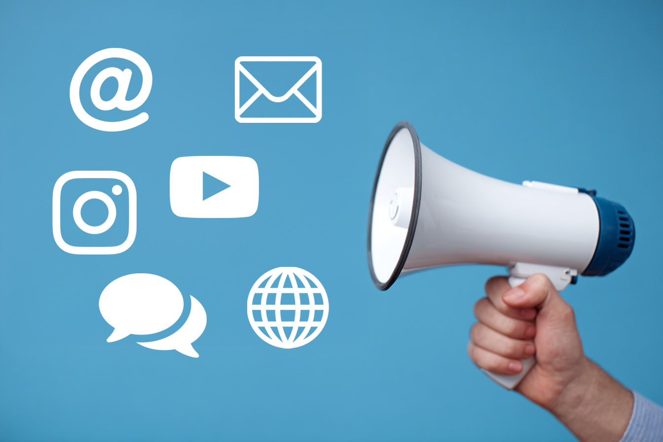 Main tenant un mégaphone avec des icônes de communication numérique et réseaux sociaux sur fond bleu