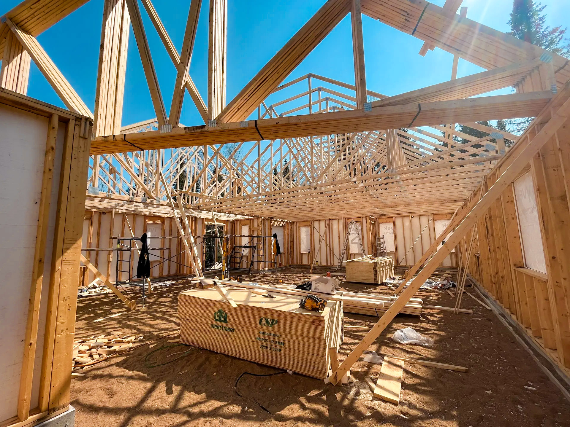 Charpente en bois d'une maison en construction avec fermes de toit exposées