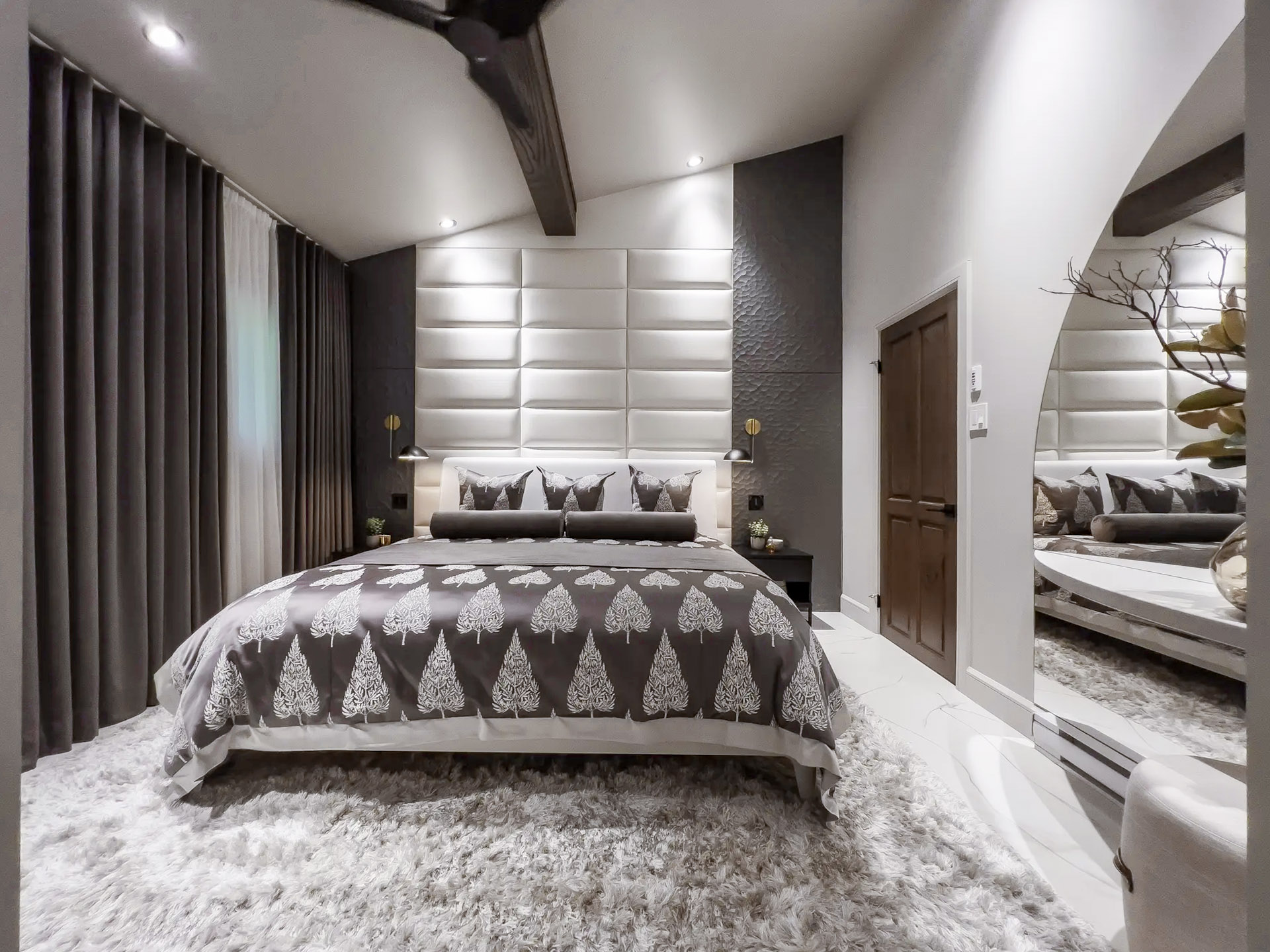 Chambre moderne et luxueuse avec lit décoratif, tapis moelleux, murs texturés et éclairage intégré