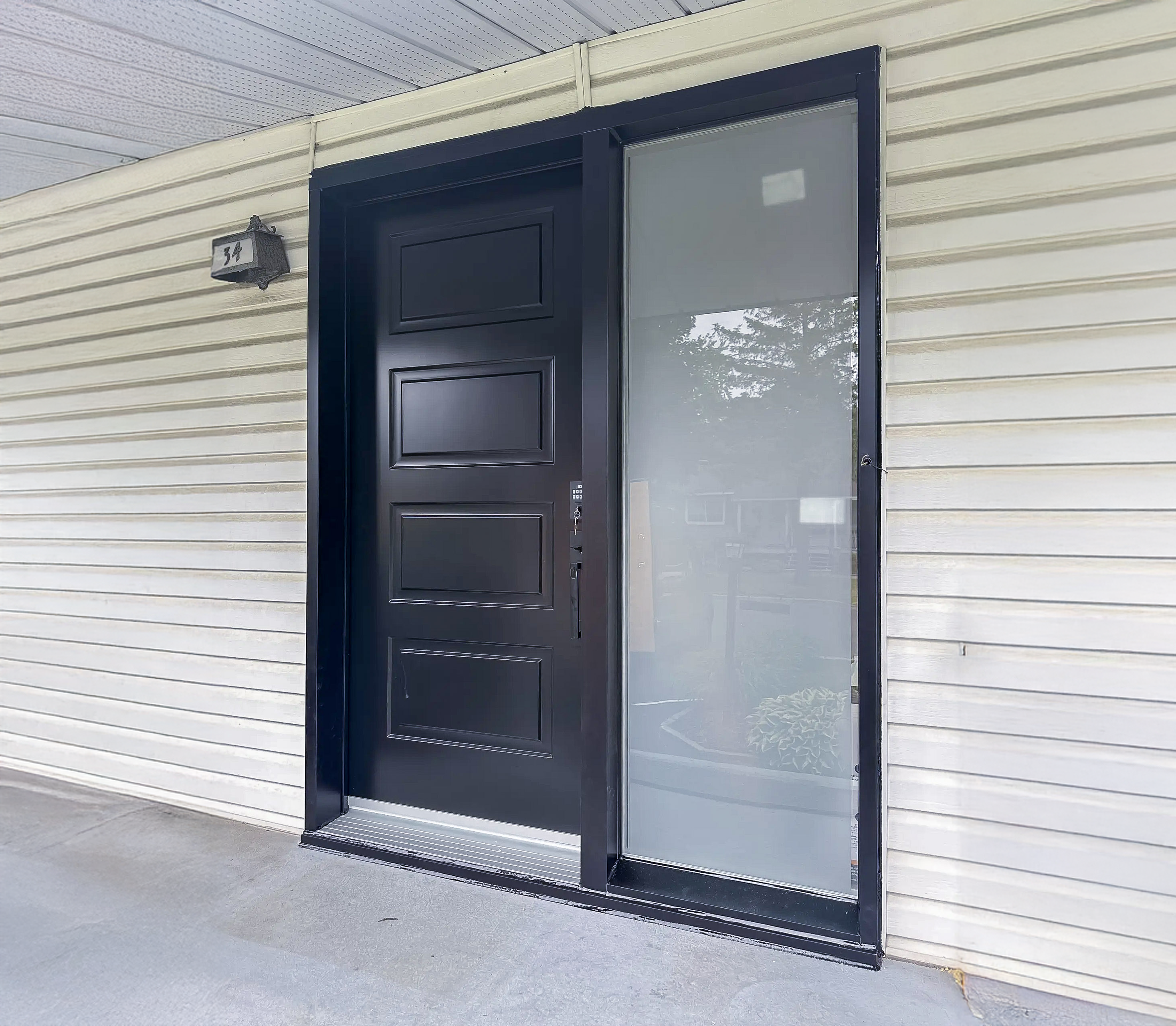 Modern black aluminum front door with a glass side panel and minimalist frame
