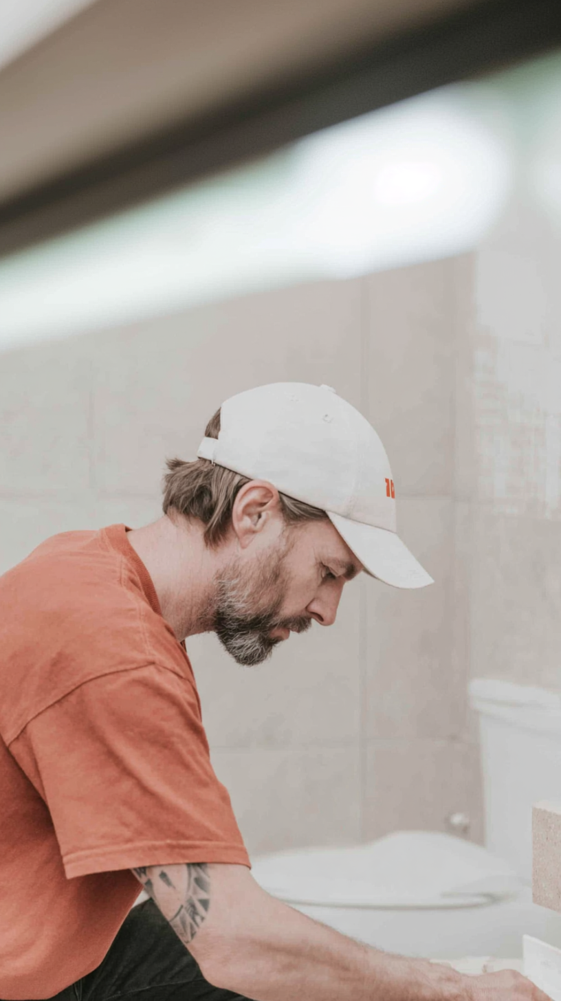 Bathroom renovation worker installing a countertop or sink with precision
