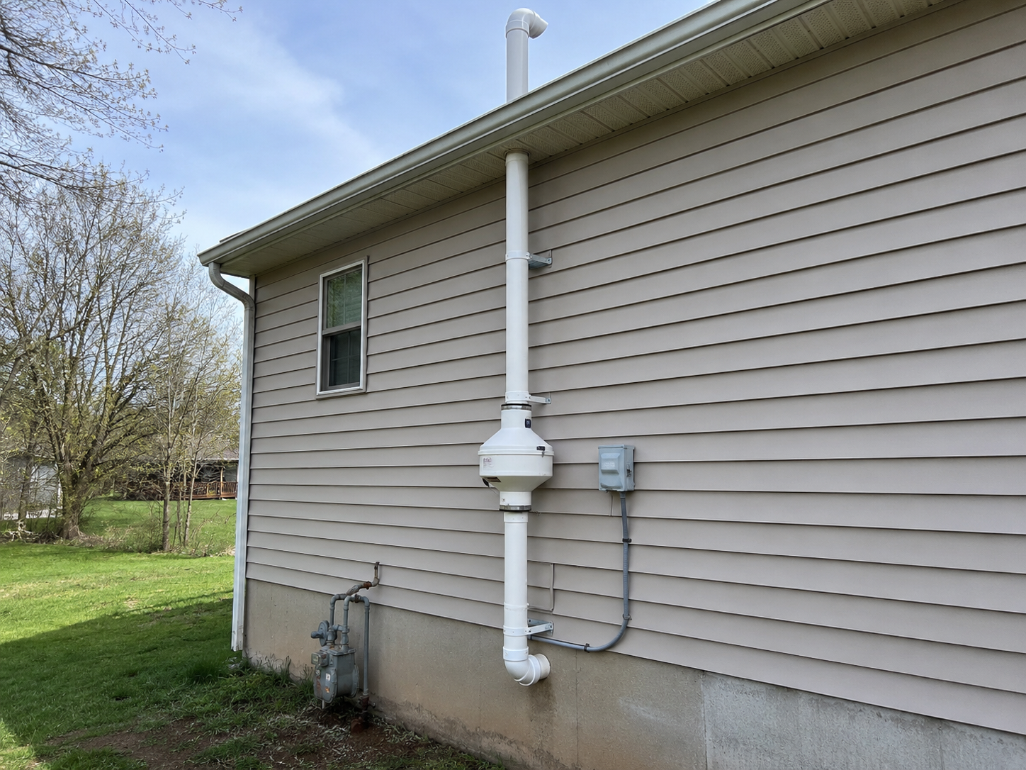 Système d’atténuation du radon installé sur le mur extérieur d’une maison.