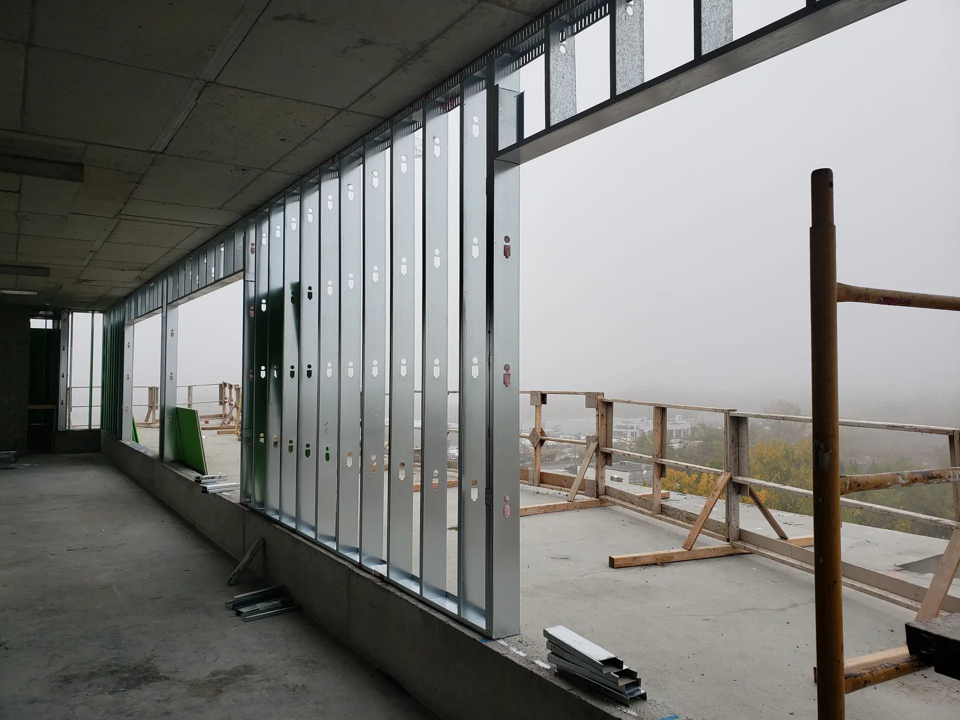 Mur en construction avec montants métalliques sur un chantier de bâtiment en hauteur