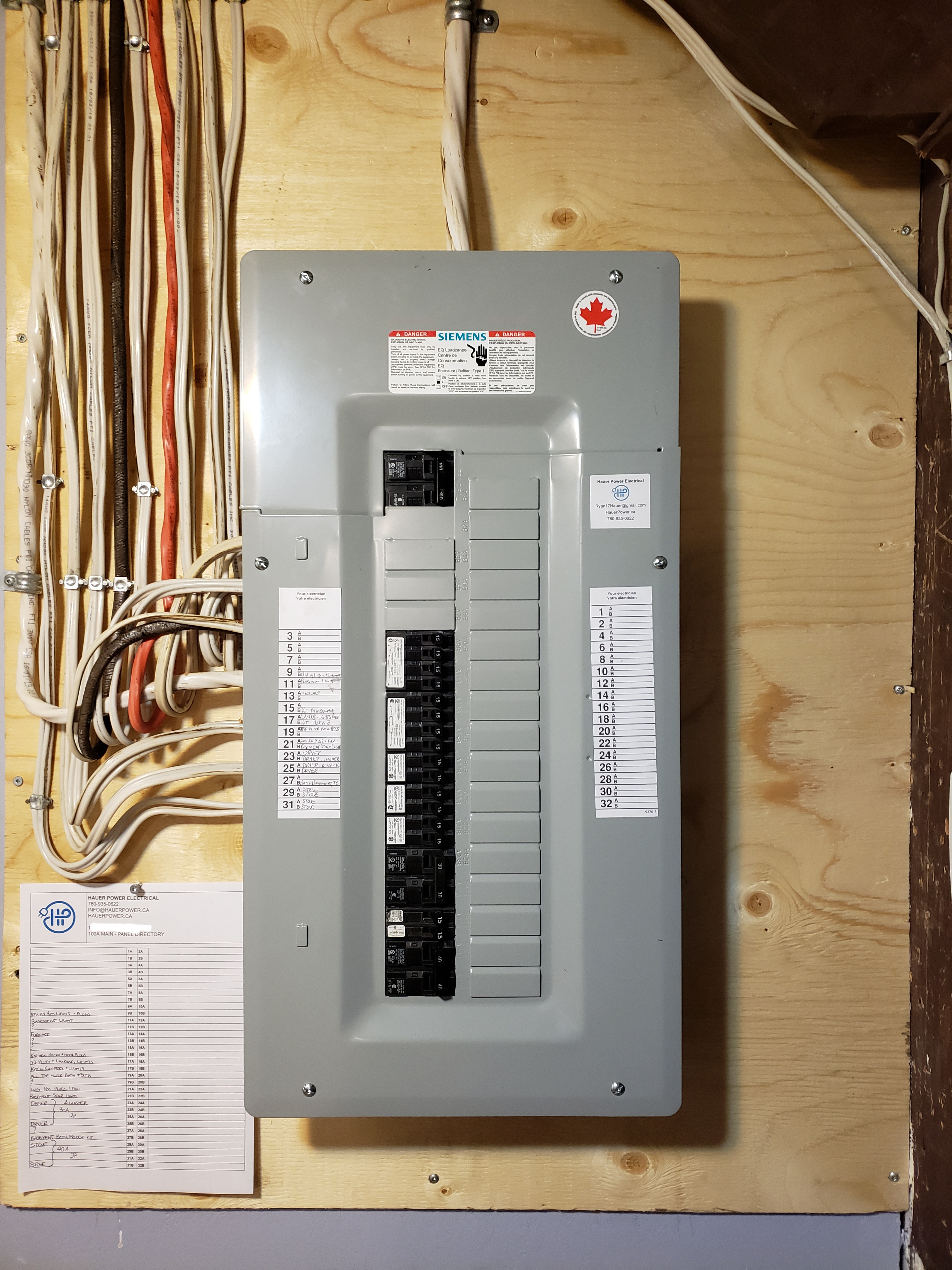 Siemens circuit breaker panel installed on a wooden board, with organized wiring for a residential electrical system.