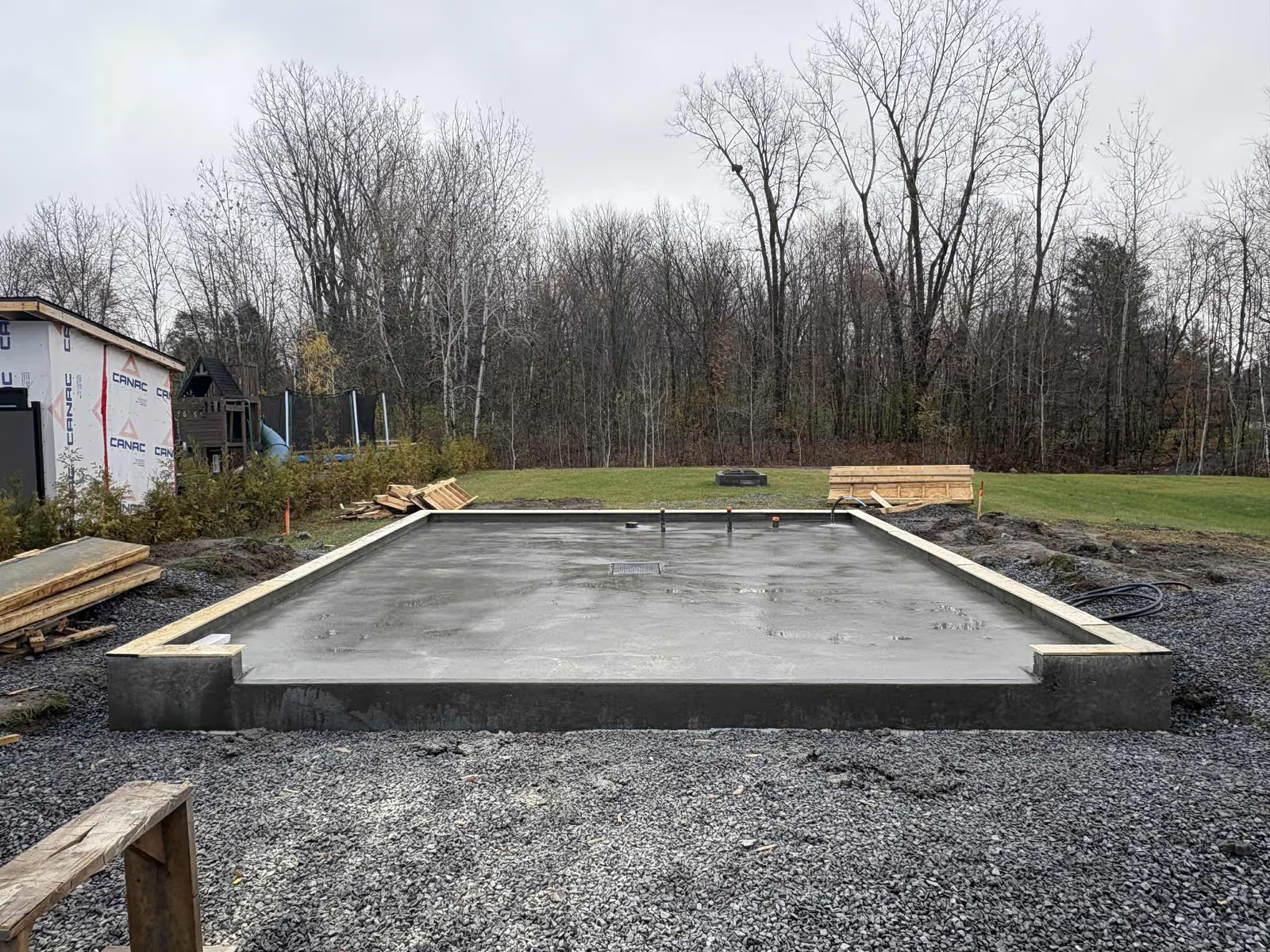 Dalle de béton fraîche pour fondation de garage sur terrain résidentiel avec coffrage et préparation du sol
