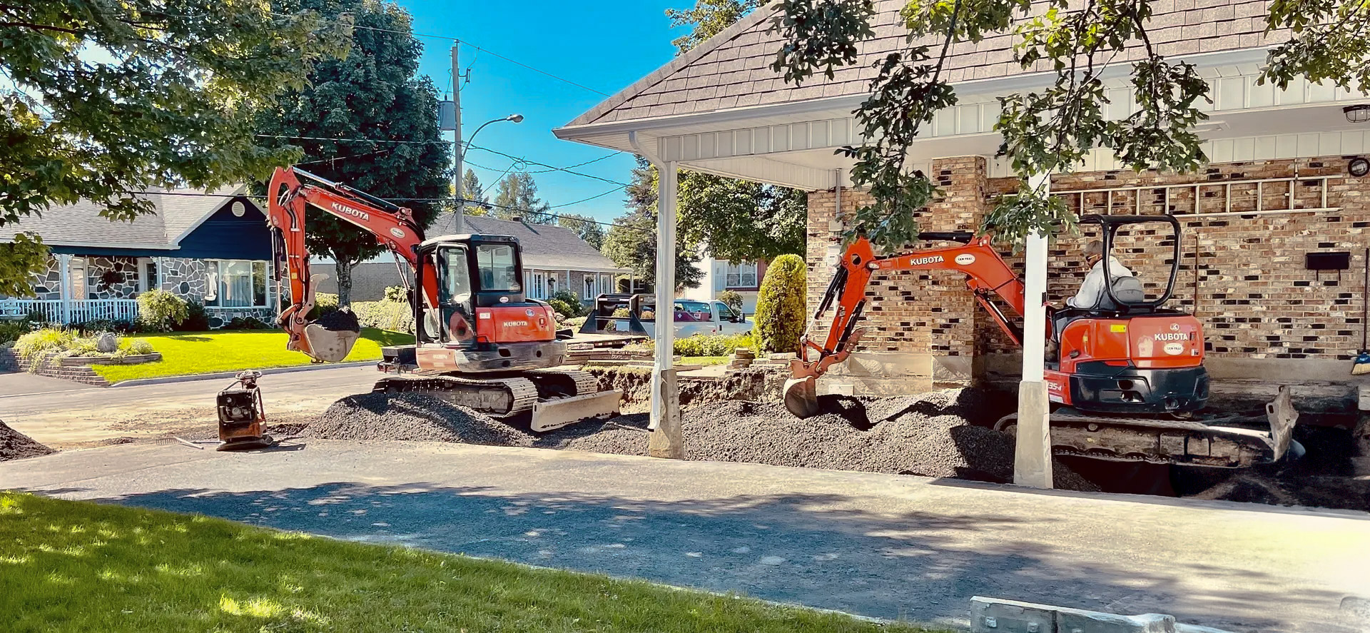 Travaux d’excavation résidentiels avec mini-pelles devant une maison de banlieue
