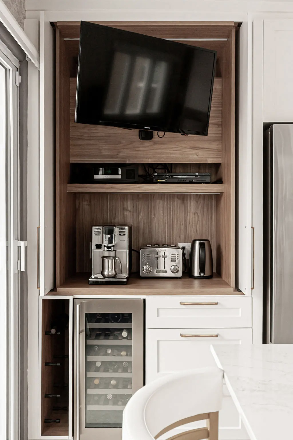 Multifunction cabinet with a television, coffee station, toaster, kettle, and built-in wine cooler.
